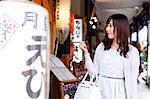 Fashionable Japanese woman at a traditional shopping street, Tokyo, Japan