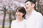 Japanese couple with cherry blossoms in a city park