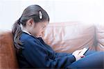 Girl playing with smartphone on sofa
