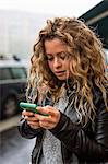 Woman in street looking at smartphone