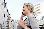 Mid adult woman strolling in city making smartphone call