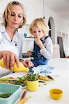 Mature woman and daughter preparing asparagus at kitchen table