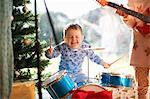 Boy and sister playing toy drum kit and guitar on christmas day