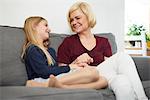 Grandmother and granddaughter relaxing on sofa