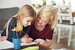 Grandmother helping granddaughter with homework at home