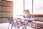 Businessman and woman looking at smartphone in office mailroom