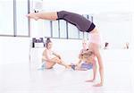 Young female ballet dancer practicing in dance studio, doing handstand