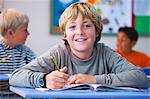 Portrait of boy in classroom, sitting at desk, doing classwork