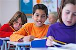 Portrait of boy in classroom, sitting at desk, doing classwork