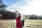 Woman in rural setting, carrying young baby in sling