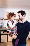 Girl sticking adhesive plasters onto father's face