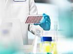 Scientist preparing blood samples in a multi well plate for clinical testing in a laboratory