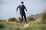 Male runner running on path at Stanage Edge, Peak District, Derbyshire, UK
