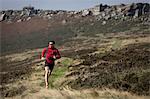 Male runner running near Stanage Edge, Peak District, Derbyshire, UK