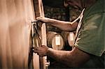 Winemaker filling wine bottle from cellar barrel