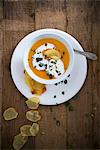 Vegan pumpkin soup with soya cream and potato chips