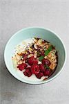 Yoghurt and raspberry muesli bowl topped with flaked almonds
