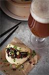 Vegan steamed bao bun filled with smoked tofu and chestnut mushrooms marinated in soy, sesame oil, chilli sauce and garlic, topped with sliced spring onions, corriander and red chilli