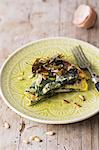 A slice of spinach tortilla with seaweed bacon and pine nuts