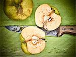 Quinces, whole and halved, with a rusty knife