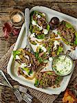 Baked potato skins, filled with spicy minted lamb shoulder and lettuce