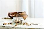 Pistachios in and next to a glass jar on a rustic kitchen table