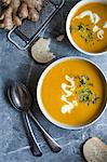 Two bowls of carrot, orange and ginger soup, view from above