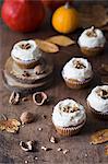 Pumpkin cupcakes with cream cheese frosting and walnuts.