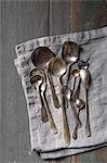 Selection of vintage silver spoons on a grey linen napkin