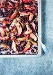 Slices of apples baked with fresh berries, oats, quinoa and pecan nuts on a baking tray
