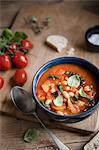 Tuscan ribollita soup with beans, tomatos, kale and basil in a bowl