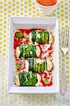 Zucchini rolls with fresh cheese filling on tomato sauce