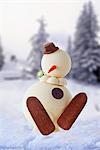 A snowman cake in front of a winter landscape