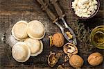 Homemade sorrentinos stuffed with ricotta and nuts in top of a wood table covered with semolina