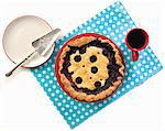 Blueberry pie from above on polka dot placemat with coffee