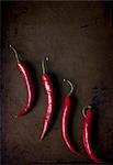 Four fresh red chillies on a metal tray