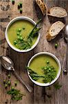 Cream of asparagus and pea soup garnished with peas. fresh asparagus and dill