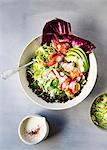 A bowl of wild rice topped with shaved brussel sprouts, avocado slices, lobster meat and a honey lemon buttermilk dressing