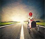 Child with a toy car drives on a country road