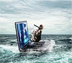 Businessman sailing on a laptop in the sea