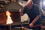 Farrier forging horseshoe on anvil