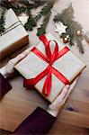 Woman holding Christmas gift tied with red bow, close-up