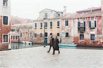 Couple strolling by canal waterfront, Venice, Italy