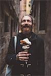 Mid adult man with gelato in dark alley, Venice, Italy