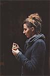 Young woman eating gelato in dark alley, Venice, Italy