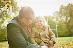 Daughter sitting on father's lap smiling