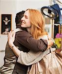 Male hairdresser hugging female customer in hair salon