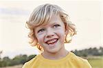 Portrait of blond-haired, blue-eyed boy on playing field