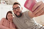 Mid adult man and daughter taking smartphone selfie