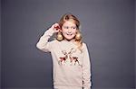 Portrait of young girl wearing Christmas jumper and bauble earrings